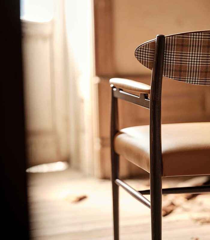 Wink chair from Bourne Furniture collection featuring a tapered-leg frame reinforced with horizontal stretchers, upholstered in camel beige leather and a check fabric reminiscent of Burberry.
